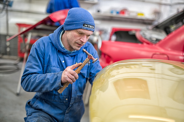 Car body specialist removing dent from peugeot bonnet